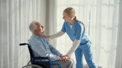 Caring Nurse Assisting Senior Man in Wheelchair