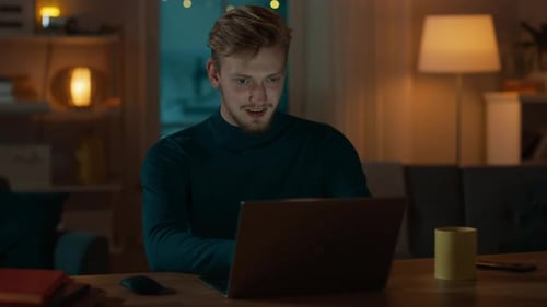 Man Using Laptop Computer At Home Late At Night