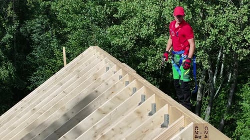 Roofer Standing on Top of Wooden Roof