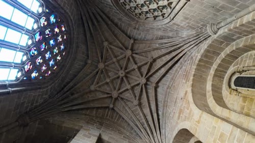 Upward orbit of interior of tower inside of ceiling with geometric designed stone supporting tower,