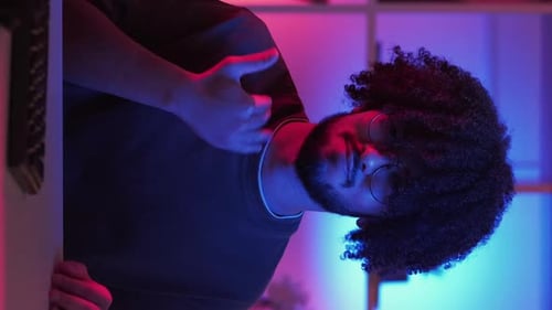 Young Adult Massages Their Sore Shoulder at Night