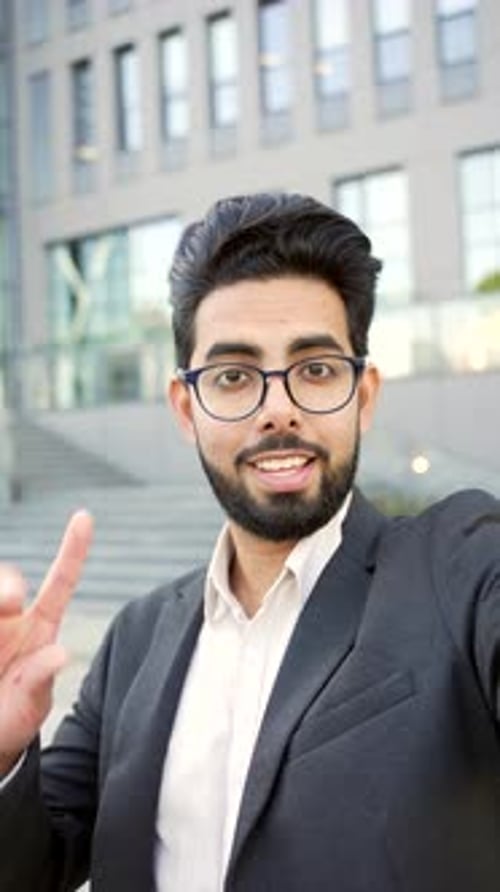 Enthusiastic Man Talking on Video Call Outside Office