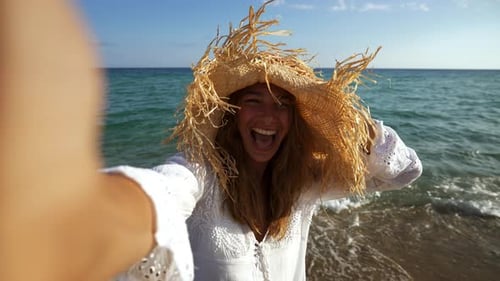 Woman Laughing While Taking Selfie on the Beach