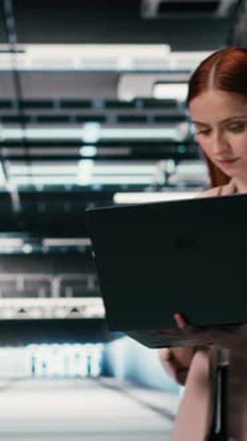 Vertical Video Woman in Modern High Tech Server Hub Using Notebook to Do Maintenance