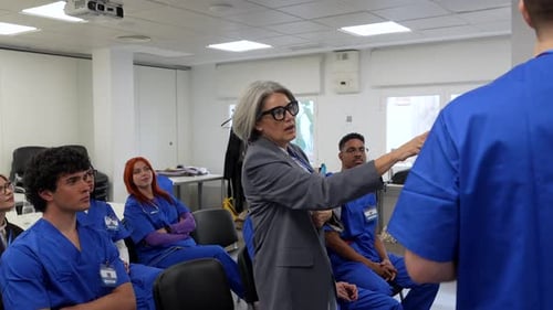 Senior female doctor teaching medical students in a hospital classroom