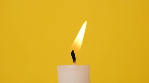 Close Up of Candle Flame on Yellow Background