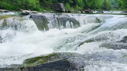 Stormy streams of water and waterfalls of a mountain river.