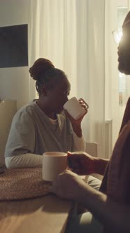 Female Nurse in Uniform Chatting to Husband over Cup of Tea