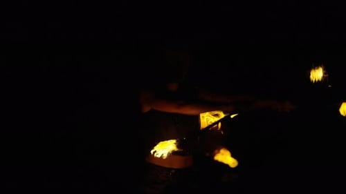 Female Fire Dancer Performing with Flaming Sticks at Night