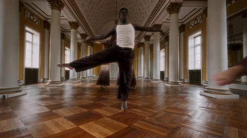 Dancers practice synchronized choreography in a grand hall