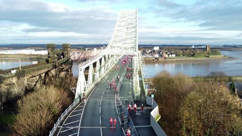 Charity Santa dash fun run over Runcorn Silver Jubilee bridge Aerial view rising upward