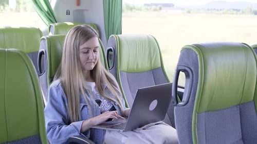Junge Geschäftsfrau auf einer Geschäftsreise arbeitet mit seinem Laptop im Bus