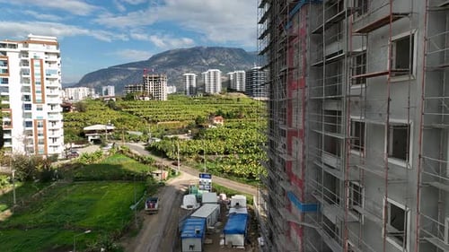 Los constructores trabajan de frente al edificio, se apoyan en el andamio