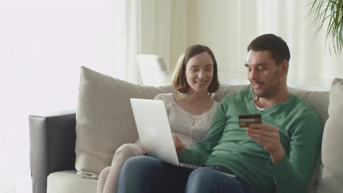 Smiling Couple Shopping Online with Credit Card