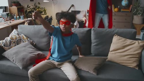Dad and Son Playing Superheroes at Home