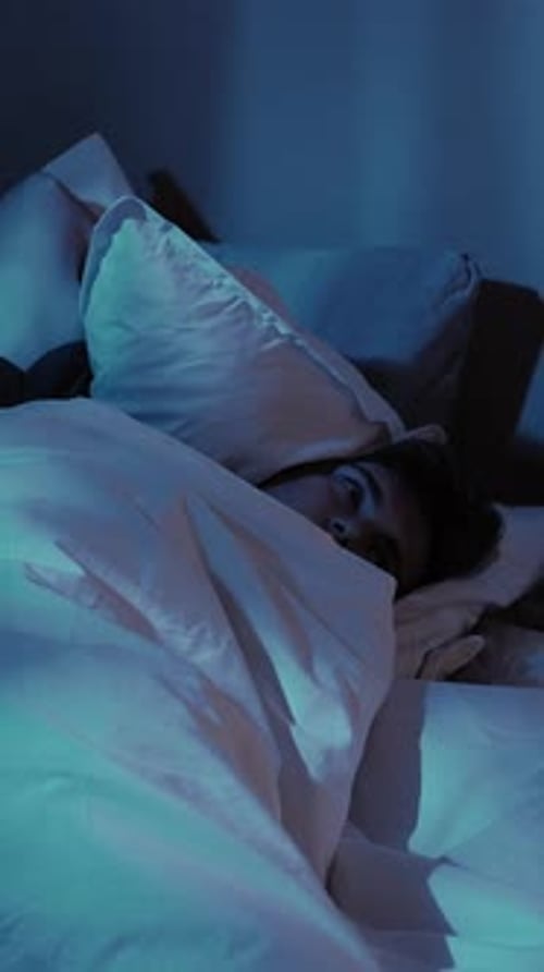 Person Adjusting in Bed at Night