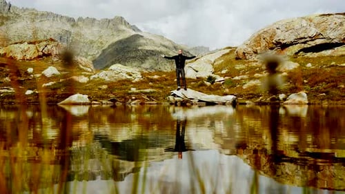 Man Stretches Arms at Alpine Lake