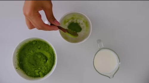 Woman Cooks at Home Matcha Tee Slowmotion of Mixing Matcha Tee Late with Electric Blender Mixed in