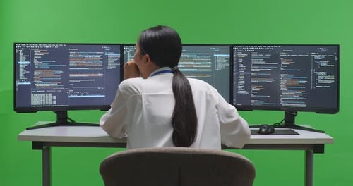 Tired Woman Developer Yawning While Write Code With Multiple Computer Screens In Green Screen Studio
