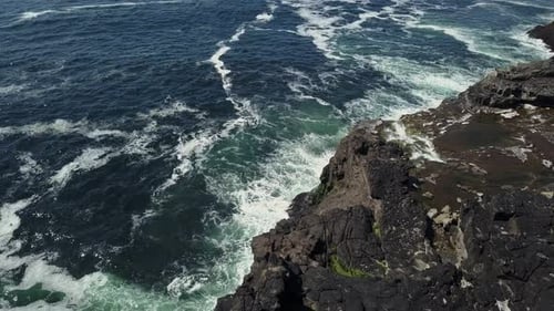 swirl around the rocky and scenic coastline, sea waves breaking over rocks