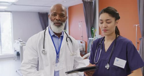 Portrait of diverse male and female doctors using tablet at hospital
