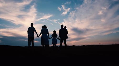 Family Walking Together in Sunset Silhouette