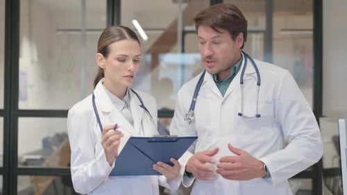 Doctors Discussing Medical Notes in Modern Hospital Office