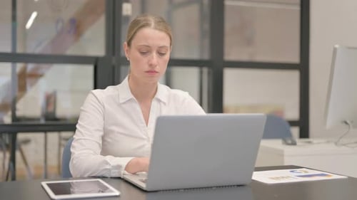 Stressed Woman with a Headache working in Office