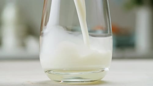 Milk Pouring in Glass Cup Closeup Glass with Yogurt Dairy Products Concept Drinking Fresh