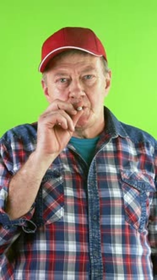 Man Smoking Cigarette in front of Green Screen