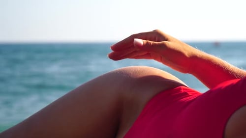 Unrecognizable Positive Woman in Red Bikini Sunbathing or Tanning on Seaside Beach During Summer