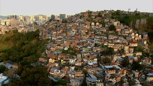 Voando acima de uma favela lotada e da paisagem urbana moderna do Rio de Janeiro, Brasil