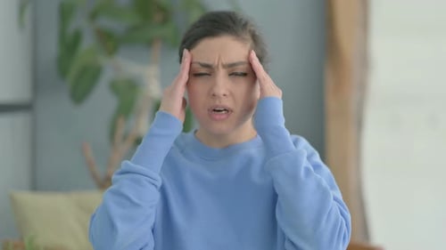Young Woman Rubbing Temples Due to Headache