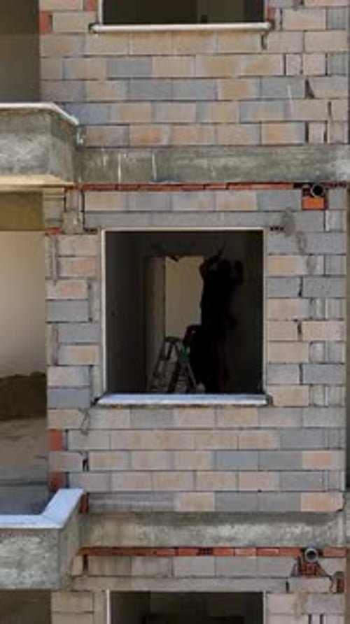 Vídeo vertical: aventura aérea en la construcción de un rascacielos admirando la transformación urbana