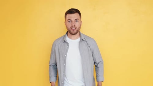 Feeling pain. Man in casual clothes standing in the studio and showing emotions