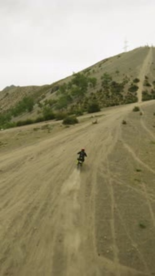 Motorcyclist Walkthroughs Track in Hilly Valley