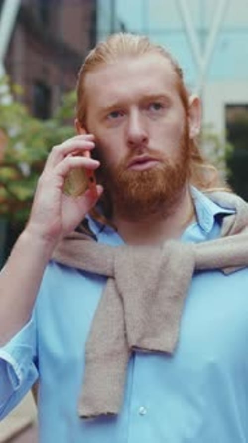 Man With Red Hair Talking on Phone Outdoors