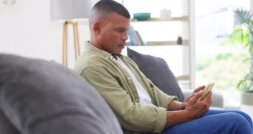 Man Using Mobile Phone While Relaxing on Couch