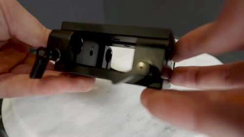 Hands Showcasing Black Metal Camera Mounting Hardware