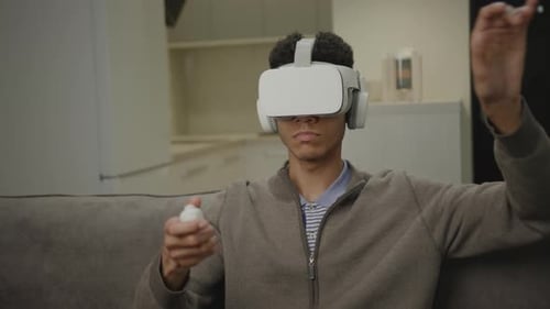 Young Man Immersed in Virtual Reality Experience at Home