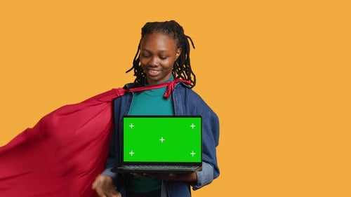 Portrait of Jolly Teenager Acting As Superhero Presenting Green Screen Laptop