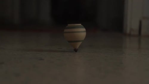 Low angle view of one wooden decorative wobbling spinning top on ground floor