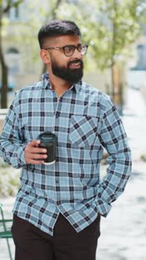 Happy Indian Man Enjoying Drinking Morning Coffee Hot Drink Relaxing Taking a Break on City Street