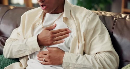 Man Coughs and Holds Chest