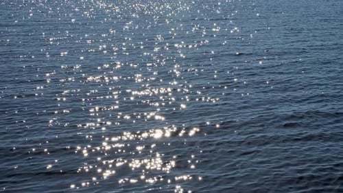 Die Oberfläche des Sees bei leichtem Wind mit der Reflexion der Sonnenblendung