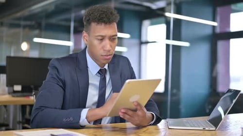 Hardworking Young Businessman using Tablet in Office