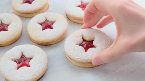 Weihnachts-Erdbeer-Linzer Cookies auf grauem Hintergrund.