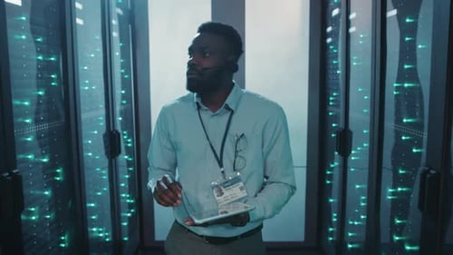 A Tech Expert Uses a Tablet to Explore a Data Centers Technology