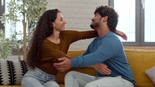 Affectionate young couple hugging on a couch