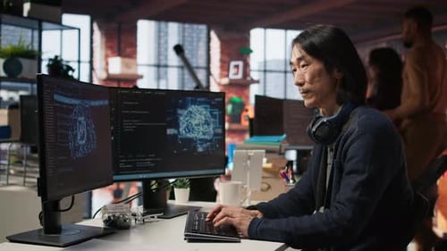 Focused Adult Typing at Computer in Urban Office